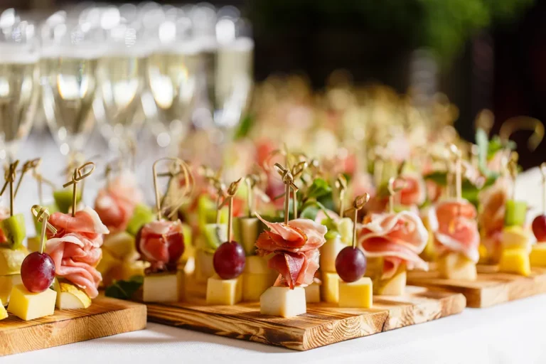 An assortment of canapes on a wooden serving board at a wedding reception.